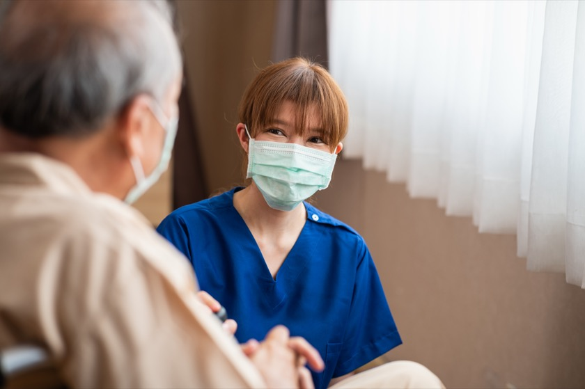 高齢者の話を聞く外国人介護スタッフ